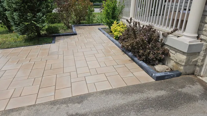 Front entrance walkway in tan slab pavers with a dark border