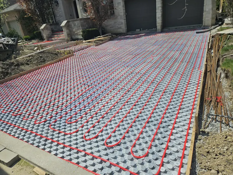 Heated driveway under construction with hydronic snow-melt tubing laid over insulation panels
