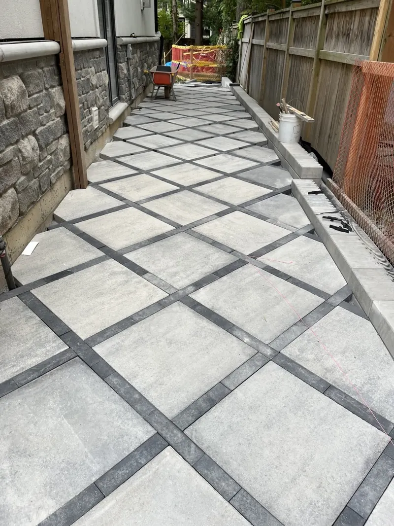 Long side walkway in light slab pavers with dark contrast banding