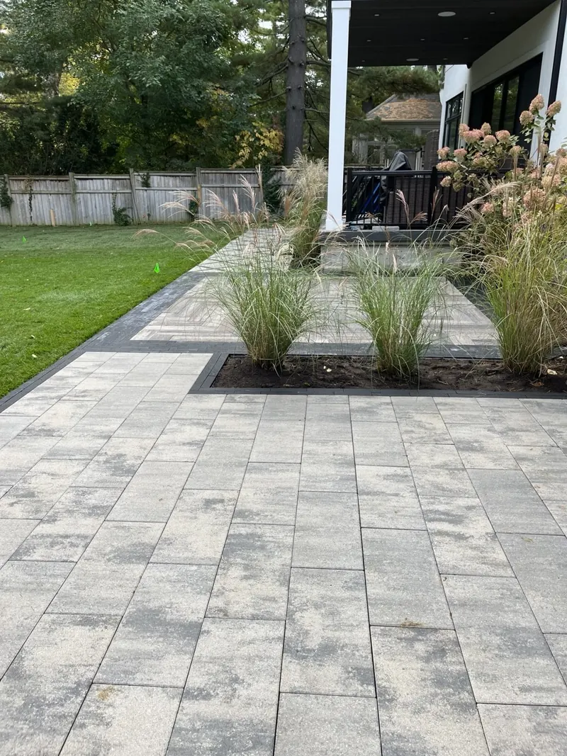 Paver walkway with a planting bed of ornamental grasses and fresh sod
