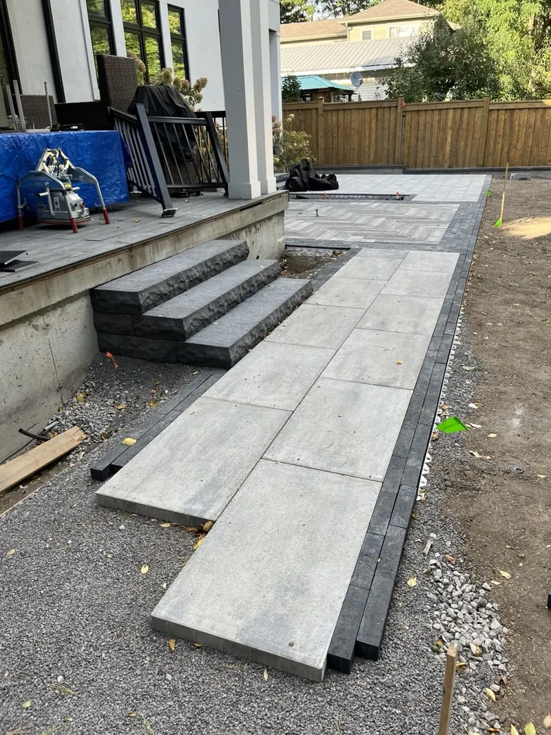 Interlock walkway and stone steps being installed on a compacted gravel base