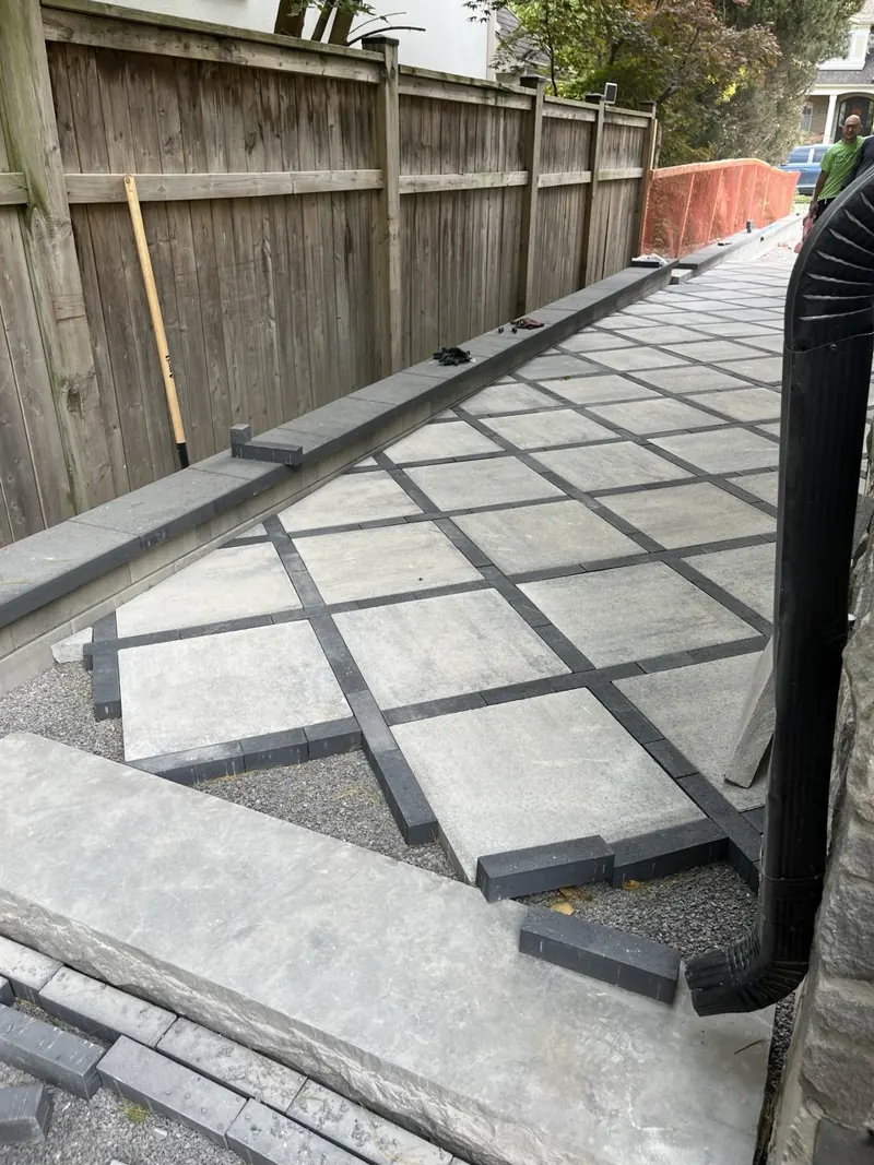 Walkway border detail with charcoal pavers and a stone coping step